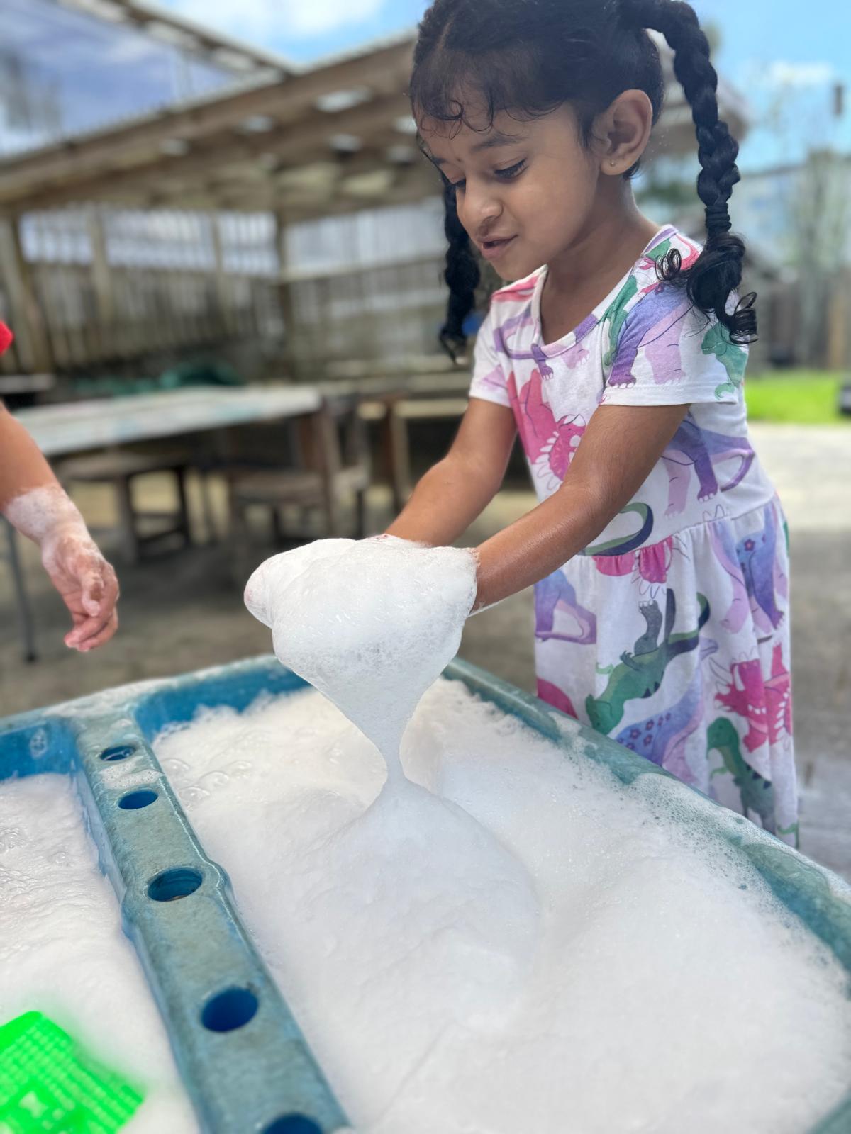 Child painting at Little Village Preschool