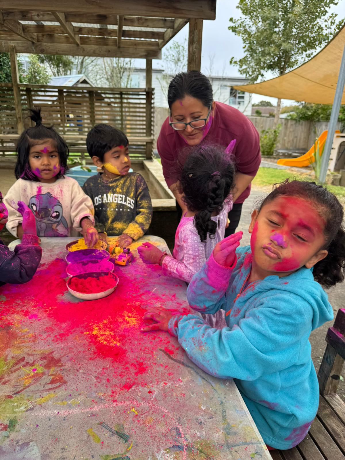 Children with their teacher at Little Village Preschool